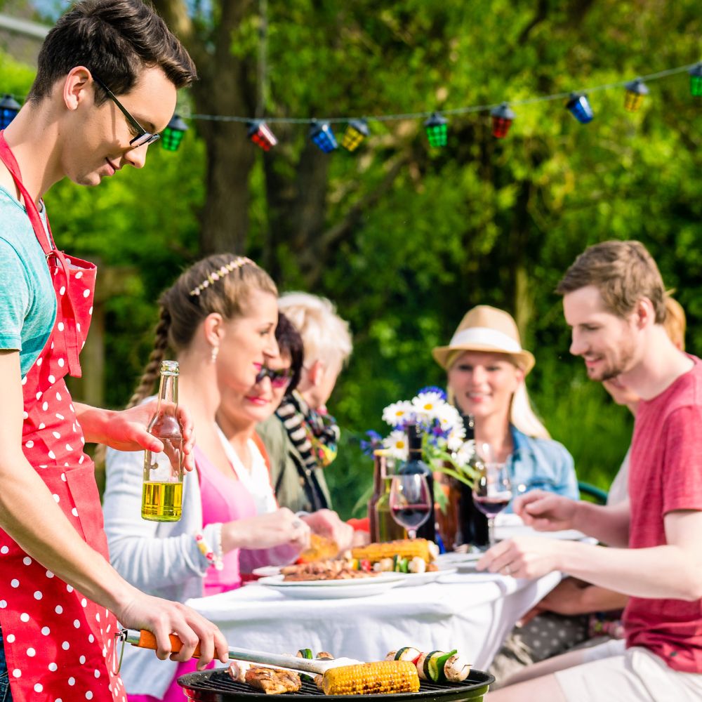 Menschen sitzen zusammen und grillen